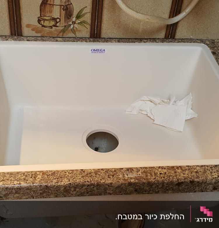 כיור מותקן על משטח שיש חום עם כלים מסביב